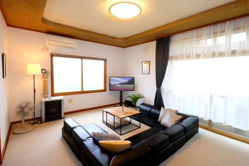 a living room with a couch and a table at Furano BLUE STAR in Furano