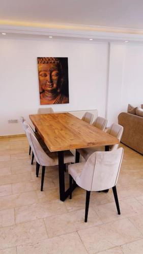 a wooden table with chairs and a painting on the wall at Tropical Mountain Villa With Pool & Sea View in Kérynia