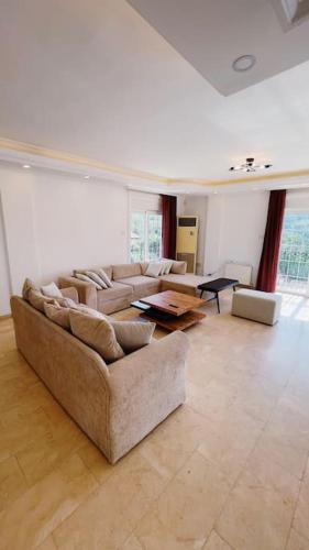 a large living room with couches and a table at Tropical Mountain Villa With Pool & Sea View in Kérynia