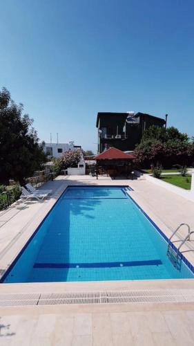 a large blue swimming pool in a building at Tropical Mountain Villa With Pool & Sea View in Kérynia