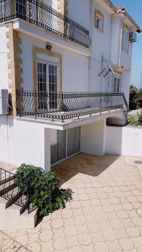 a building with a balcony and a plant in front of it at Tropical Mountain Villa With Pool & Sea View in Kérynia