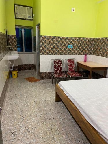a bedroom with a bed and a table and a sink at Hotel Bhagwat Palace in Gaya