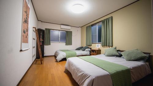 a hotel room with two beds and two windows at 福助白露double bath Spacious Japanese house Nipponbashi Dotonbori Namba Nara Direct in Osaka