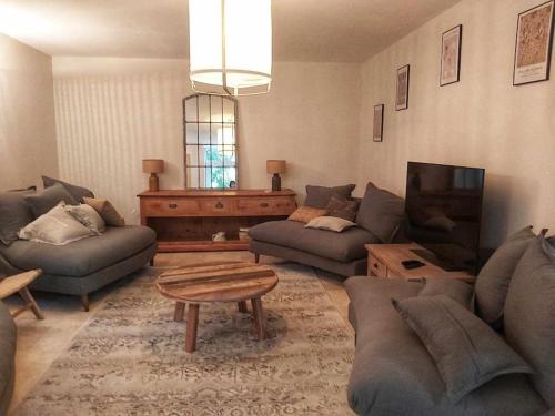 a living room with two couches and a tv at La Bastide de combe laval in Saint-Laurent-en-Royans