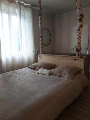 a bedroom with a large bed with a wooden headboard at La Bastide de combe laval in Saint-Laurent-en-Royans