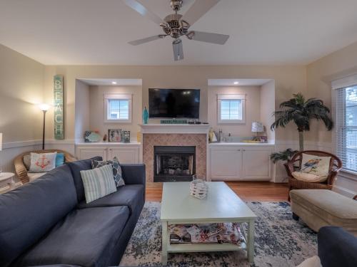a living room with a blue couch and a fireplace at After Dune Delight in Kure Beach