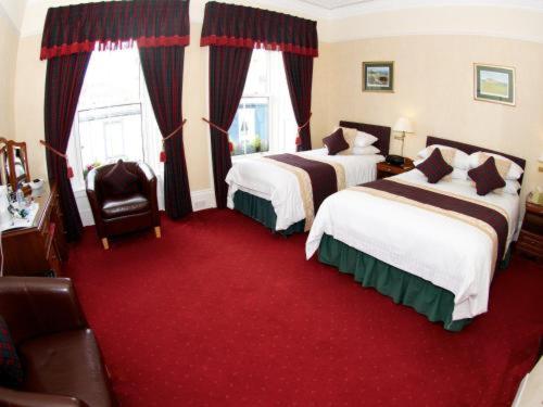 a hotel room with two beds and a red carpet at Daviot Guest House in Ayr