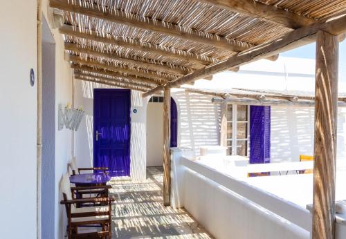 a hallway with a blue door and chairs at Sorokos Koufonissia in Koufonisia