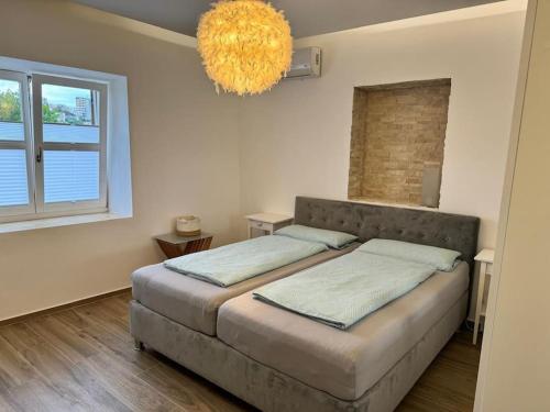 a bedroom with a large bed with a chandelier at Ulcinj - Stonehouse in Oldtown with sea view in Ulcinj