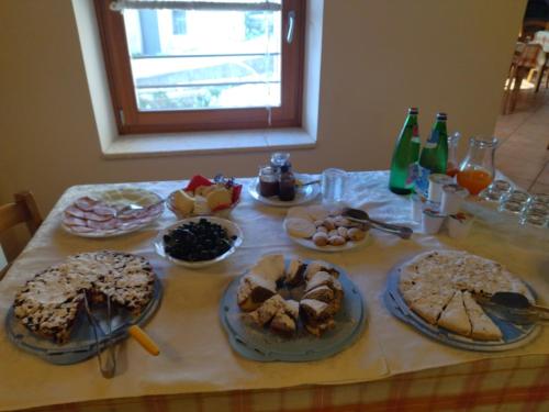 a table with many plates of food on it at Agriturismo El Bocolar in Marano di Valpolicella