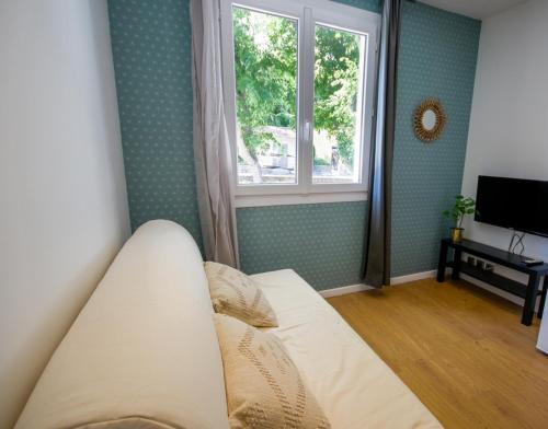 un lit dans une chambre avec une fenêtre dans l'établissement La maison des roses 2 Avignon, à Villeneuve-lès-Avignon