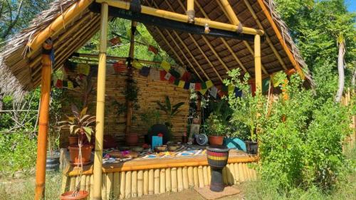 a large wooden house with a thatched roof at Uncle Hippie's Dream in Gili Meno