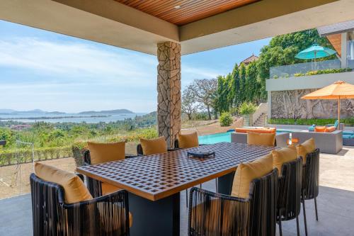 an outdoor dining area with a table and chairs at White Monkey Villa - Private Pool & Jacuzzi in Pantai Cenang