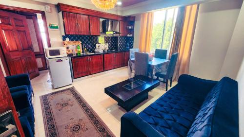 a living room with a couch and a table and a kitchen at Aqua Apartment Murree in Murree