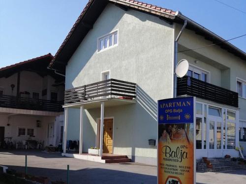 a building with a sign in front of it at Apartman OPG Balja in Garešnica