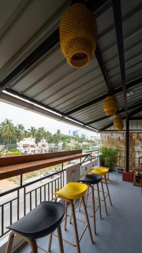 a row of chairs and tables on a balcony at Trippr Mysuru in Mysore