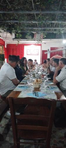a group of people sitting around a long table with wine glasses at vecchio west in Agerola
