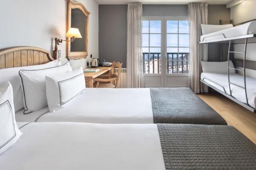 a hotel room with two beds and a balcony at Melia Sierra Nevada in Sierra Nevada