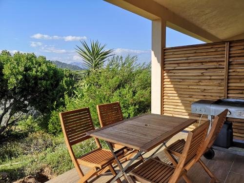 - une table et des chaises en bois sur une terrasse avec barbecue dans l'établissement Appartements avec jardin entre Porto-Vecchio et Figari - Casa Mattiste, à Sotta