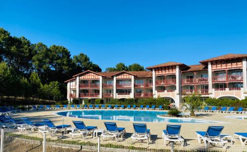 un complexe avec des chaises et une piscine dans l'établissement Appartement Biscarrosse lac-golf, à Biscarrosse