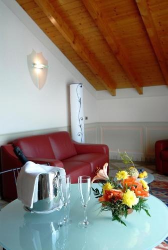 a living room with a red couch and a table with flowers at Hotel La Bussola in Orta San Giulio