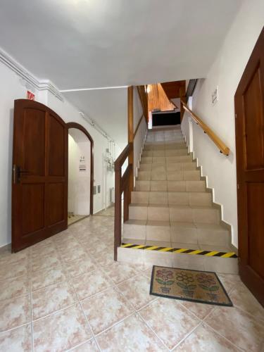 a hallway with a staircase with a door and a rug at Katalinkert Panzió in Győr