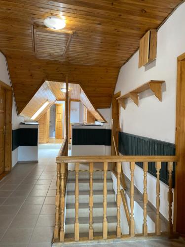 a staircase in a house with wooden ceilings at Katalinkert Panzió in Győr