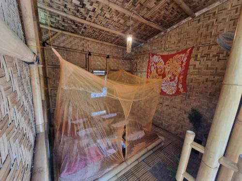 a net in a room with a wall at Uncle Hippie's Dream in Gili Meno