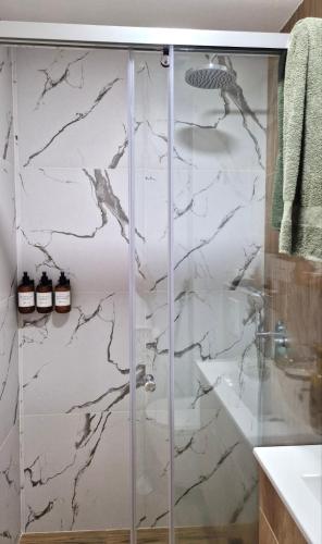 a bathroom with a shower with white marble at YOUR CHOICE in Bar