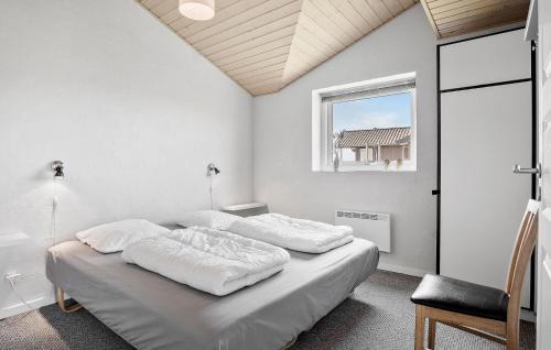 a white bedroom with two beds and a window at 4 Bedroom Lovely Home In Faaborg in Fåborg