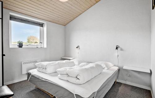 a bedroom with a bed with white sheets and a window at 4 Bedroom Lovely Home In Faaborg in Fåborg