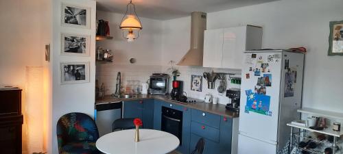 une cuisine avec des armoires bleues et un réfrigérateur blanc dans l'établissement Une résidence à 30 minutes du coeur de Paris !, à Romainville