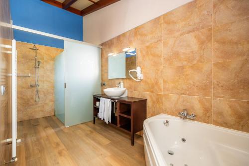 a bathroom with a tub and a sink and a shower at Finca Conies Romaní in Manacor