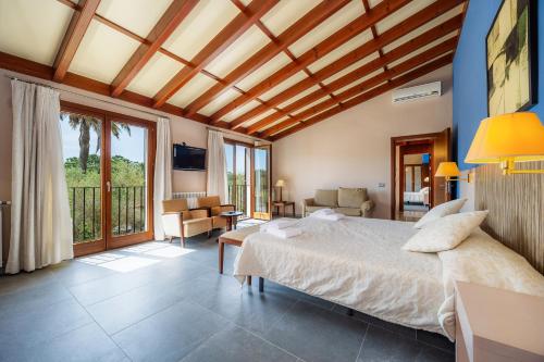 a bedroom with a bed and a living room at Finca Conies Romaní in Manacor
