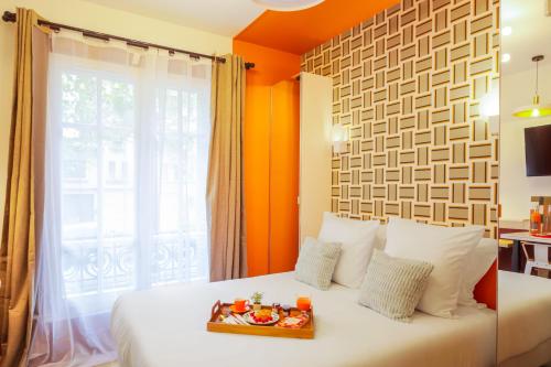- une chambre avec un lit et un plateau de nourriture dans l'établissement WS Montparnasse - Maine, à Paris
