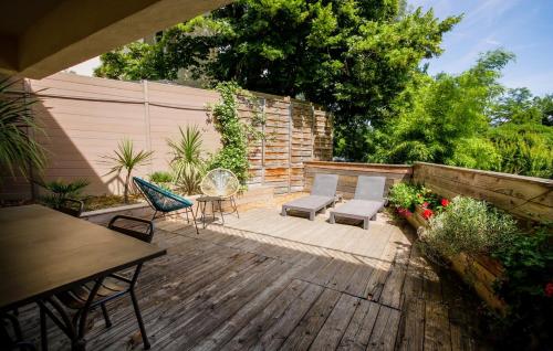 une arrière-cour avec une terrasse en bois, des chaises et une table dans l'établissement La maison des roses 5 Avignon, à Villeneuve-lès-Avignon