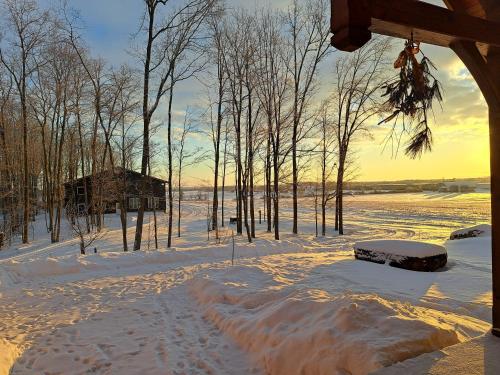 a snow covered field with trees and a building at Luxury farm Stay, Alexandria in Glen Robertson