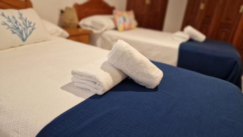 a pile of folded towels sitting on a bed at Apartamento Raxobrisamar in Raxo