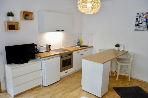 a kitchen with white cabinets and a counter top at Cozy Apartment in Dresden Neustadt in Dresden