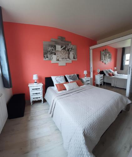 - une chambre avec un lit blanc et des murs rouges dans l'établissement Gite des sablons, à La Heunière