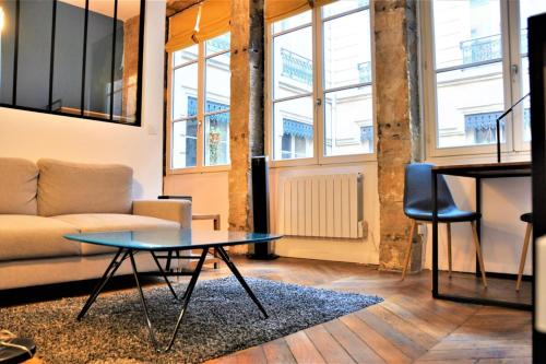a living room with a couch and a table at Le Bleu hypercentre Presque île in Lyon