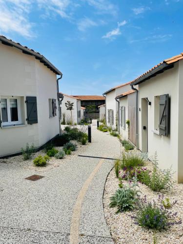 une route de gravier menant à une rangée de bâtiments dans l'établissement Résidence Grand Tilleul, à Jonzac