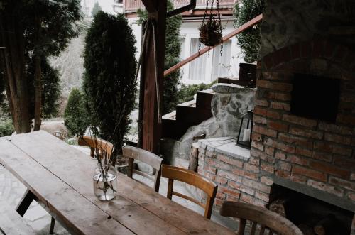 a wooden table with chairs and a brick fireplace at Apartament Zdrojowy in Muszyna