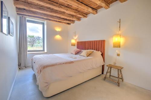 une chambre avec un grand lit avec une fenêtre dans l'établissement Le Domaine de la Férédie, à Vieux-Mareuil