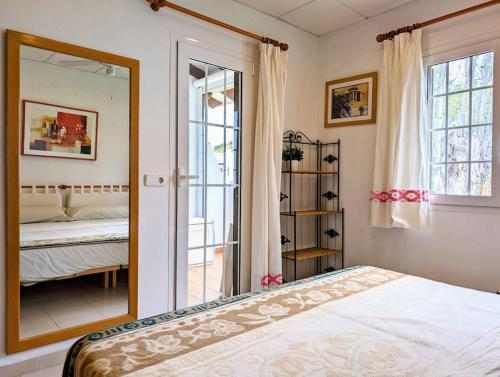 - une chambre avec un miroir, un lit et une fenêtre dans l'établissement Apartamento turístico en Son Bou con vistas al mar, à Son Bou