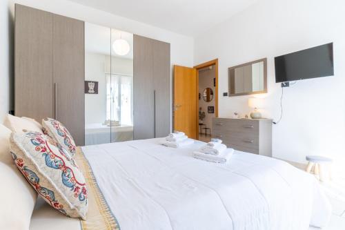 a bedroom with a white bed with a tv on it at I Mori Cà in Modica