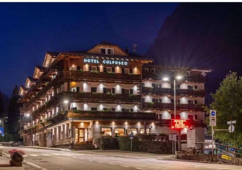 a hotel on a city street at night at Hotel Colfosco in San Martino di Castrozza
