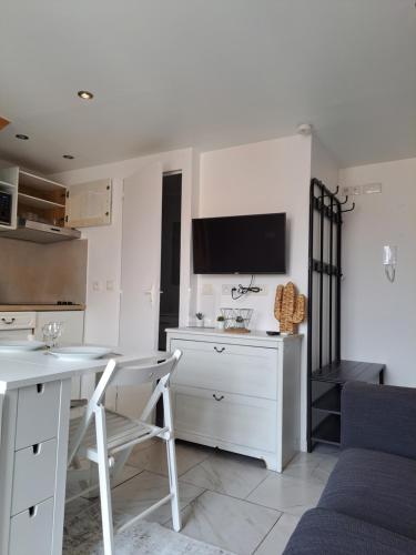 Il comprend une cuisine avec une table et un bureau avec une télévision. dans l'établissement 2 pieces en Duplex à 5 minutes de la plage N2, à Saint-Laurent-du-Var
