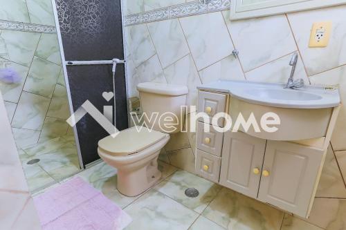 a bathroom with a toilet and a sink at Linda chacara em Mogi das Cruzes in Mogi das Cruzes
