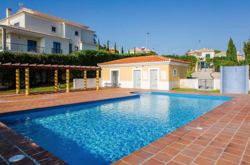 a swimming pool in front of a house at Apt MC - with pool in Alcantarilha